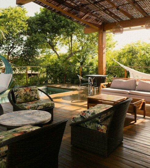 Covered patio with seating, hammock, and pool view